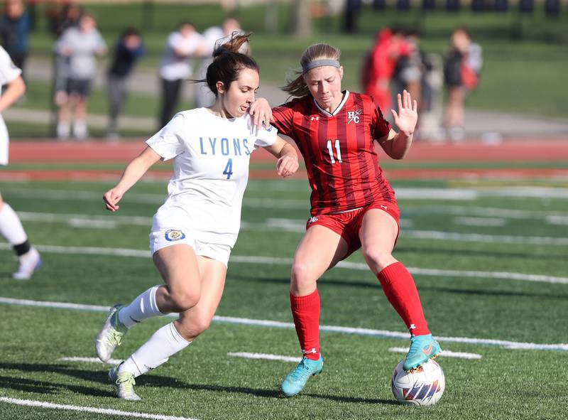 Hinsdale Central's Peyton Rohn (11) goes for the ball against Lyons Township's Niamh Griffin (4) during the girls varsity soccer match between Lyons Township and Hinsdale Central high schools in Hinsdale on Tuesday, April 18, 2023.