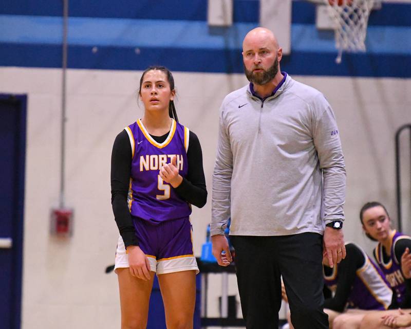 Downers Grove North's head coach Stephen Bolt talks with Downers Grove North's Campbell Thulin (5) during a free throw on Saturday Dec. 21, 2024, while taking on Downers Grove South at Downers Grove High School.