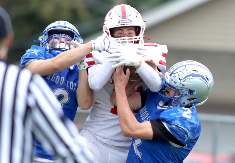 Woodstock’s JD Canty, left, and Maximus Miller, right, tussle with Ottawa’s Archer Cechowicz in varsity football at Larry Dale Field on the campus of Woodstock High School Saturday.