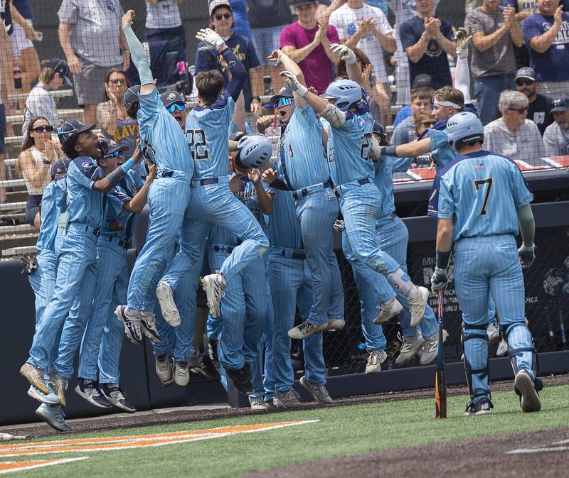 Ottawa Marquette’s #22 Griffin Dobberstein celebrates with his team after hitting a solo homer against Father McGivney Saturday, June 7, 2025, during the Class 1A state baseball final at Illinois Field in Champaign.