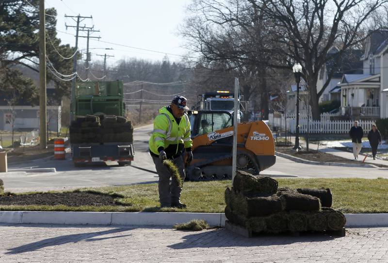 A worker installs sod at the new roundabout on Tuesday Nov. 22, 2022, as workers put the finishing touches on the roundabout at intersection of Lake Avenue and South and Madison streets in Woodstock. Construction on the roundabout near Woodstock's downtown is expected to wrap up this week, opening traffic and marking the end of several months of construction. The roundabout has been in the works for several years and was built out this year.