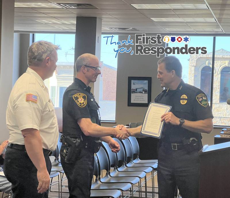 Sycamore Fire Chief Bart Gilmore looks on as Communications Lt. Joseph Rood of the DeKalb County Sheriff’s Office accepts a certificate from Sycamore Police Chief Jim Winters at a the Sycamore City Council meeting on April 15, 2024, when the City Council approved a proclamation declaring April 14-20, 2024, to be National Public Safety Telecommunicators Week in Sycamore.