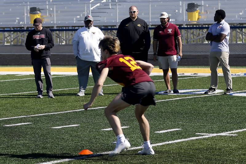 College coaches watch as Richmond-Burton's Jonathan Sulek runs a drill at the Northern Burbs Football Showcase on Monday, May 4, 2026, at Johnsburg High School. Over 165 players from 15 teams demonstrated their football skills to over 60 college coaches.