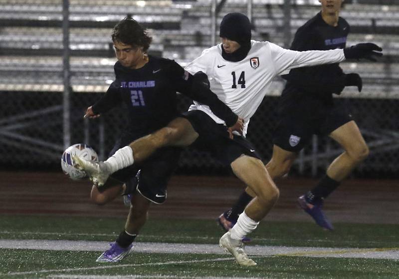 McHenry's Kyren Rivard (right) kicks the ball away from St. Charles North's Vincent Garbato during an IHSA Class 3A Huntley Regional boys soccer semifinal match on Tuesday, Oct. 21, 2025, at Huntley High School.