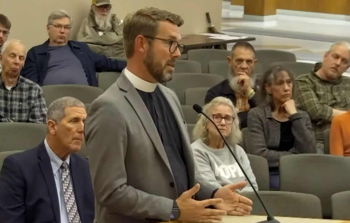 The Rev. Scott Zaucha of Trinity Episcopal Parish speaks at the Crystal Lake City Council meeting on Oct. 21, 2025, opposing plans to landmark a historic building on the church's property.
