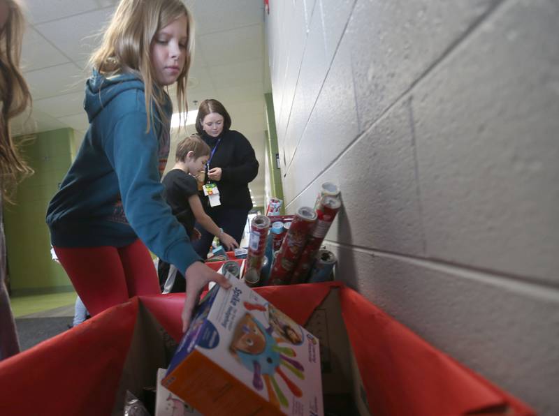 Marie Austin places toys into a bin during the Small School Big Hearts campaign on Tuesday, Dec. 2, 2025 at Dimmick School in La Salle. The “Small School, Big Hearts” campaign is a toy drive organizded by third graders and celebrates the power of kindness, generosity and community spirit. Gifts will be wrapped and sent to Officer Santa with the La Salle Police Department and St. Jude. The school is accepting donations through Dec. 12.