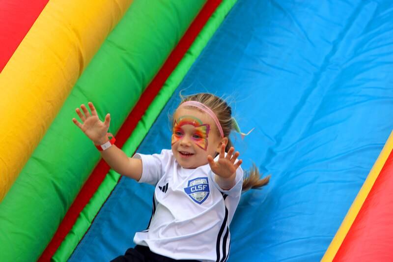 Lilli Drain, 4, of Crystal Lake takes a spin on an inflatable slide during the Johnny Appleseed Festival in downtown Crystal Lake on Saturday Sept. 28, 2024, in Crystal Lake.