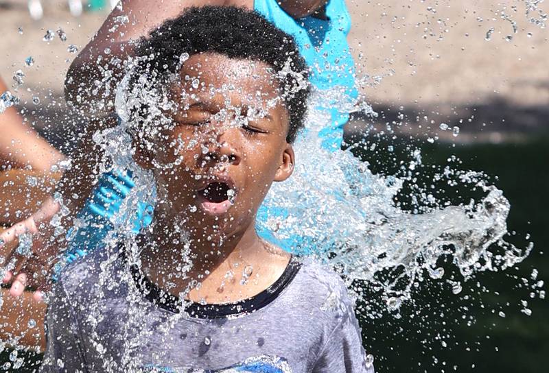 Jamirius Nichols, 7, from DeKalb, gets a face full of water Tuesday, June 14, 2022, in the splash pad at Welsh Park in DeKalb. Temperatures reached nearly 100 degrees Tuesday and highs are expected to remain in the 90's through Thursday.