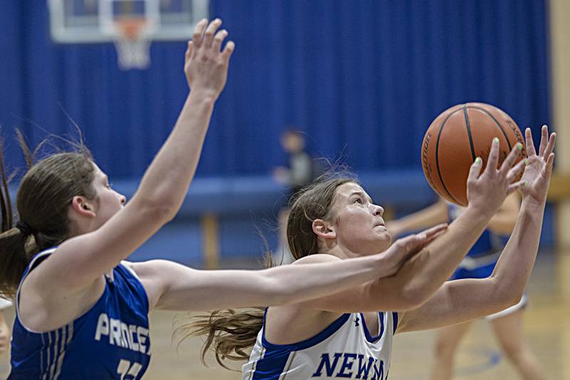 Newman’s Lucy Oetting hauls in a rebound against Princeton’s Camryn Driscoll Thursday, Dec. 14, 2023 at Newman High School.