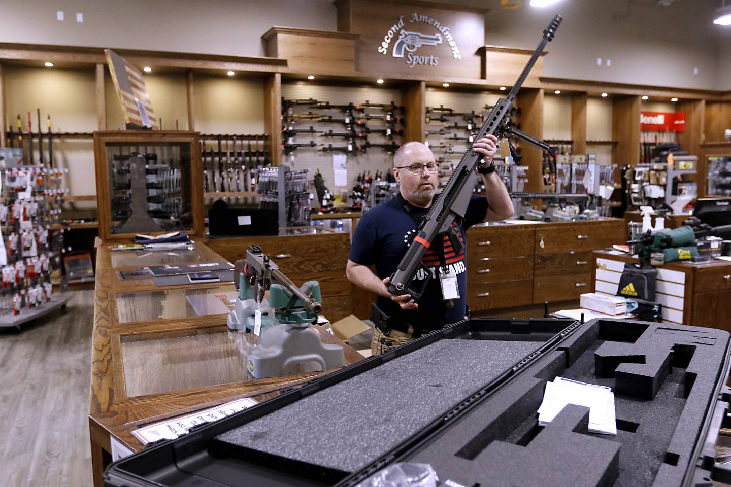 Jon Sabia, a sales lead at Second Amendment Sports, in McHenry, takes apart a Barrett 50 caliber BMG, that can no longer sold Wednesday Jan. 11, 2023, after a new gun law restricting a number of firearms and attachments and limiting ammunition was signed into law Tuesday night by Gov. JB Pritzker. The bill, along with requiring registration for such guns if already owned and enhancing gun restraining orders, hits at semiautomatic weapons.