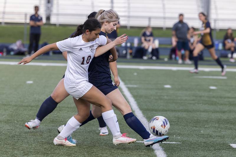 Sterling’s Reagan Schueler and and Moline’s Jenna Saucedo work for the ball Tuesday, April 30, 2024 at Sterling High School.