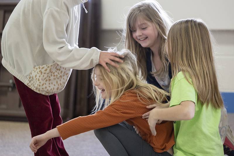 Lucie Shippert, first grader at St. Anne’s School in Dixon, is mobbed by classmates Tuesday, Jan. 28, 2025, after winning a game of paper cup and plate stacking.