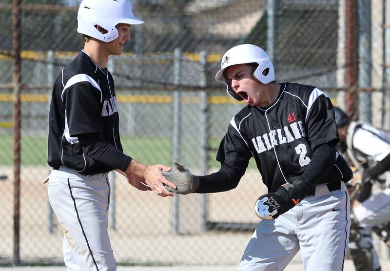 Kaneland's Kanon Baxley (right) celebrates after scoring a run with teammate Aidan Whildin Tuesday, April 28, 2026, during their game against Sycamore at the Sycamore Community Sports Complex.