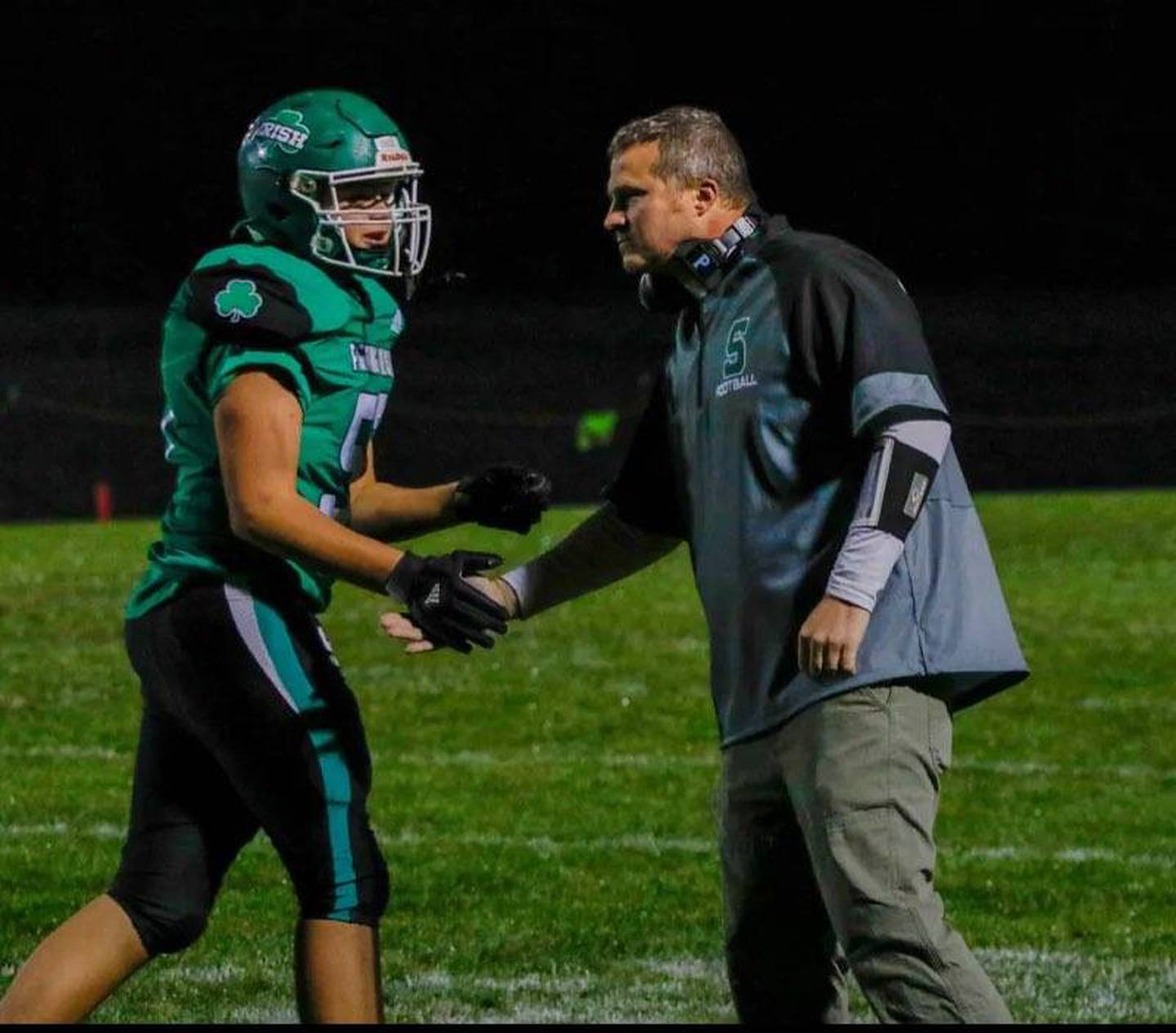 Seneca head football coach Terry Maxwell congratulates his son, Zebadiah, after a play during a game last season.