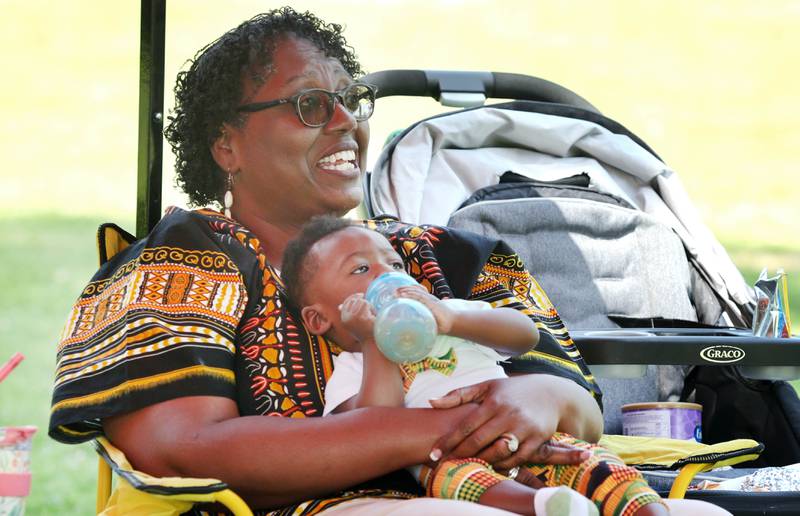 Desiree Bailey, and her 10-month-old grandson Davon Diggs, from DeKalb, keep cool in the shade during the second annual Juneteenth celebration Sunday, June 19, 2022, at Hopkins Park in DeKalb.