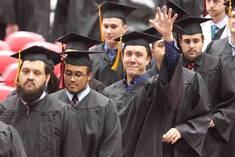 Candidates for graduation wave to friends and family as they head to their seats Saturday, May 14, 2022, during the first of two undergraduate commencement ceremonies at Northern Illinois University in DeKalb.