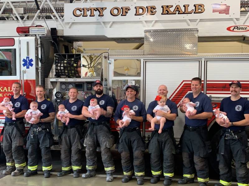 Eight DeKalb firefighters pose for a recent picture with their newborns in September 2022. Each of the newborn babies was born within months of each other. (Photo provided by DeKalb Fire Department)