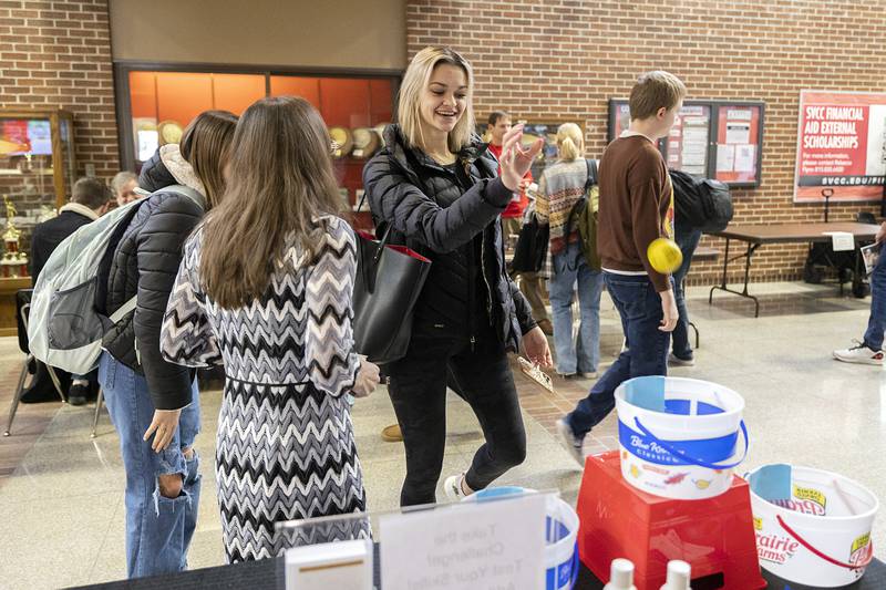 Alicia LeFevre of Rock Falls tries her luck by tossing a ball into a bucket at Sauk Valley Community College’s ADA Club booth Wednesday, Feb. 2023.