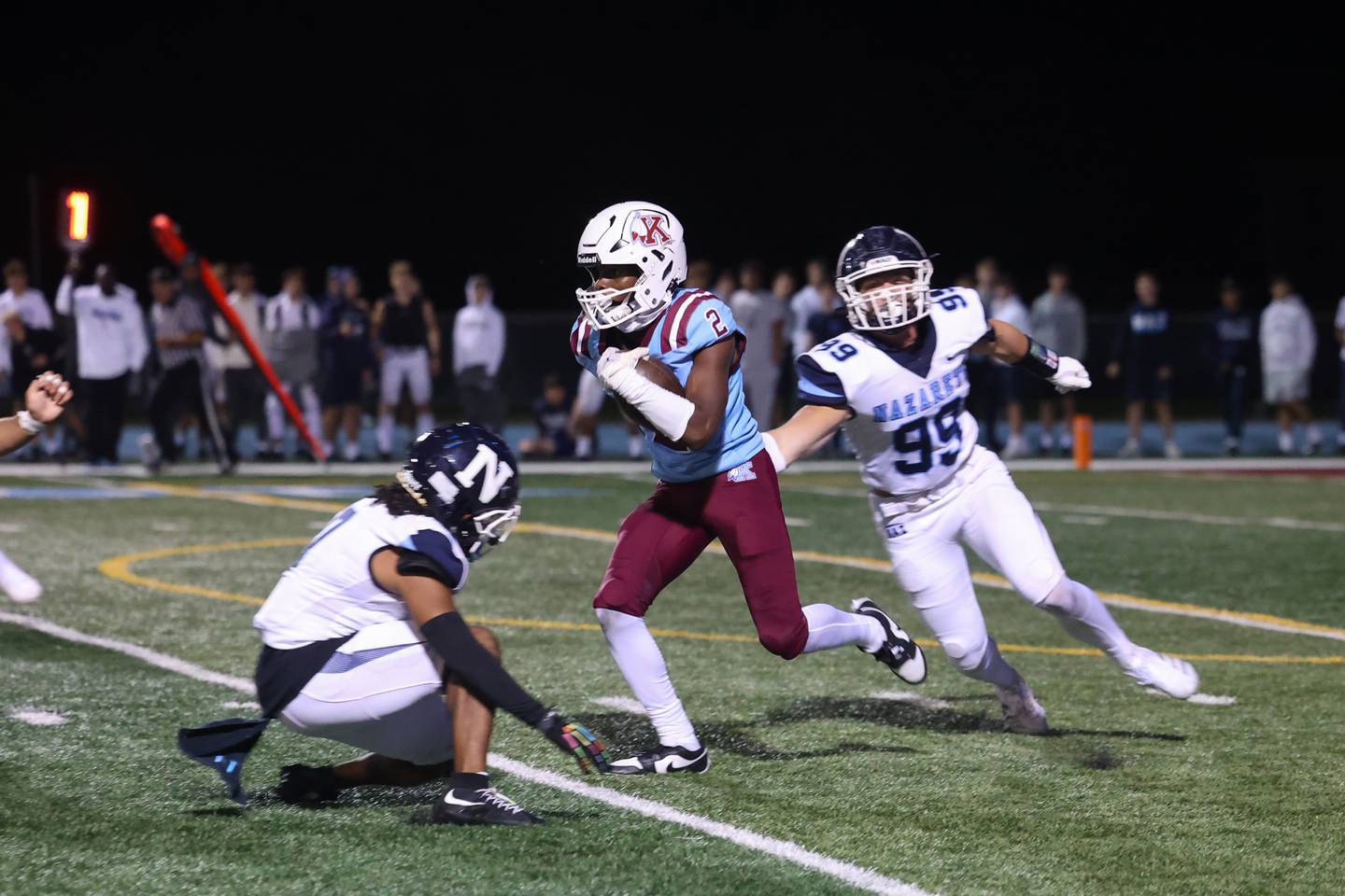 Kankakee's Ezekiel Sherrod evades two Nazareth defenders on a punt return during Kankakee's 33-12 loss to Nazareth on Friday, Aug. 29, 2025.