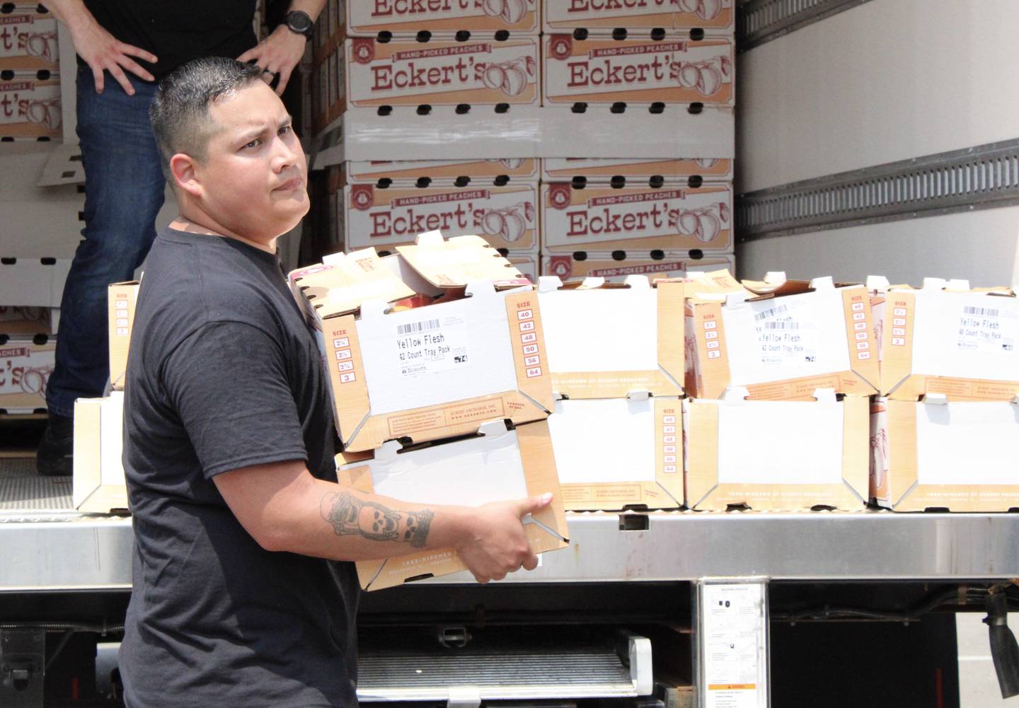 Gabriel Rodriguez, 34, of Dixon Kiwanis helps unload peaches from a refrigerated truck on Thursday, July 29, 2021, at Dixon High School parking lot.