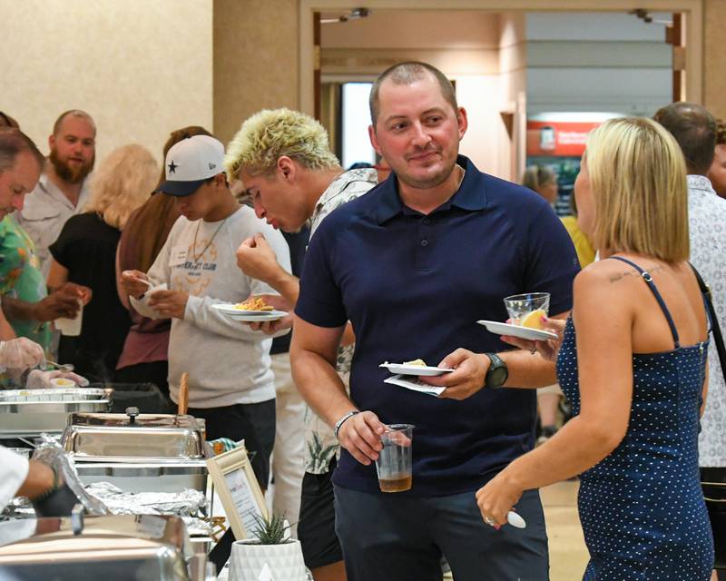 Community members sample food on Saturday, Aug. 9, 2025, during the 21st annual CASA DeKalb County's Men Who Cook fundraiser held at Northern Illinois University's Barsema Alumni and Visitors Center.