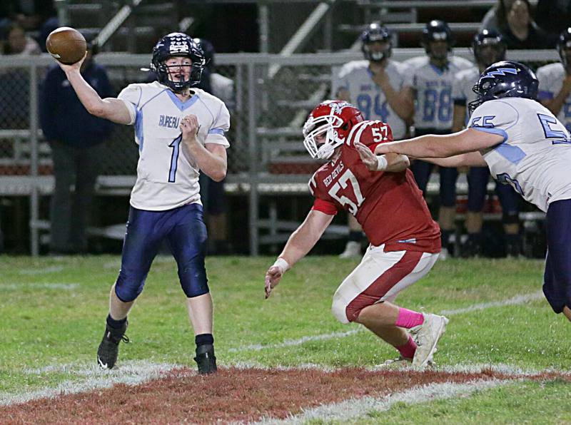 Bureau Valley's quarterback Bryce Helms throws a pass as teammate Jon Dybek (55) blocks Hall's Joel Koch (57) on Friday, Oct. 21, 2022 at Richard Nesti Stadium in Spring Valley.