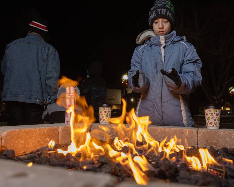 Gaige Dorsett warms his hands during the Christmas Parade on December 7, 2025 in Spring Valley.