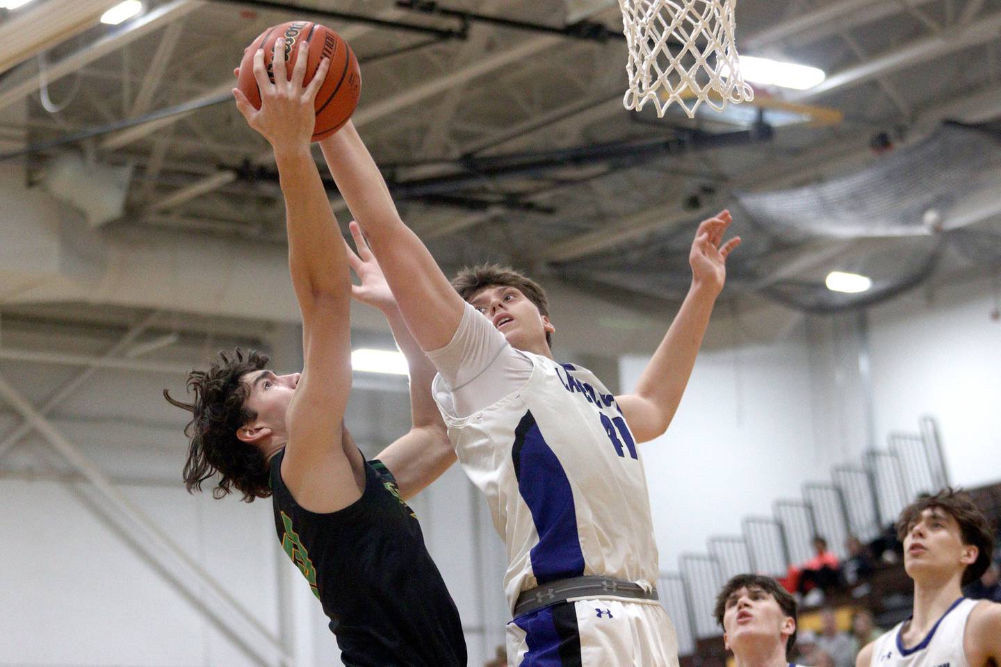 Crystal Lake South’s CJ Regillio, left, battles Lake Zurich’s Anton Strelnikov for the ball in Hinkle Holiday Classic boys basketball tournament game action at Jacobs High School Wednesday.