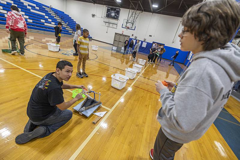 Rock Falls Middle School eighth graders Sabastian Lerma (left) and Adam Vervink talk about strategy before starting their accuracy competition. Each team has one minute to get as many projectiles into the baskets; the farther the target, the more points.