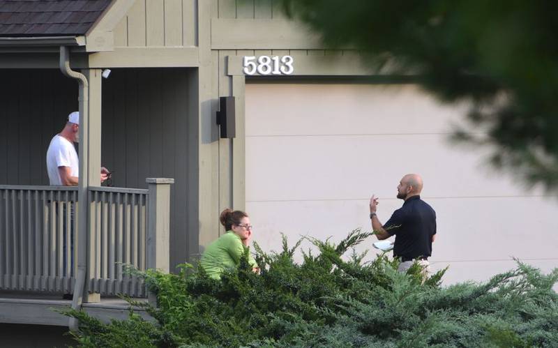 An investigator talks to residents who live near the scene of a shooting on the 5800 block of Wild Plum Road near Crystal Lake the morning of Wednesday, Aug. 9, 2023.