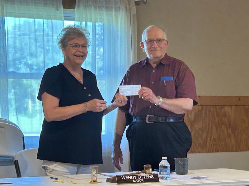 Fulton Mayor Wendy Ottens (left) accepts a $300 check from the Masonic Lodge for renovations at School Park.