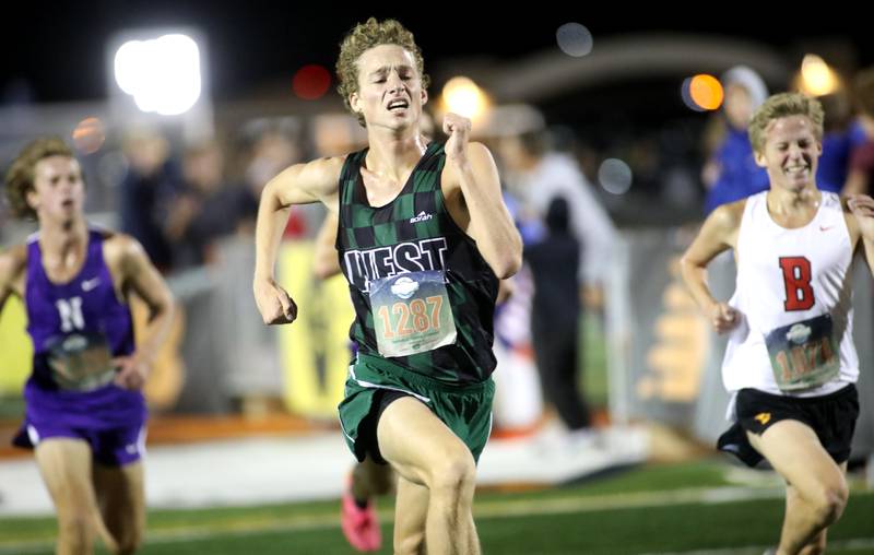 Glenbard West’s Graham Faris runs to the finish of the varsity boys race during the Naperville North Twilight Cross Country Invitational on Wednesday, Oct. 9, 2024 in Naperville.