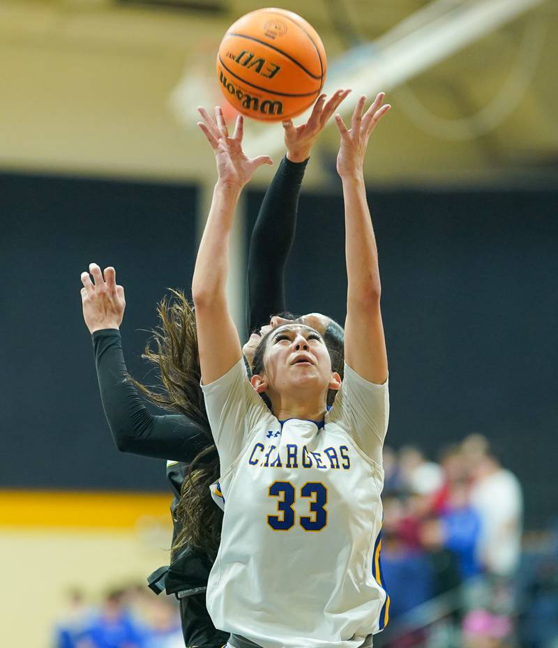 Aurora Central Catholic's Sofia Corral (33) rebounds the ball against Waubonsie Valley's Danyella Mporokoso (10) during a basketball game at Aurora Central Catholic High School on Thursday, January 30, 2025.