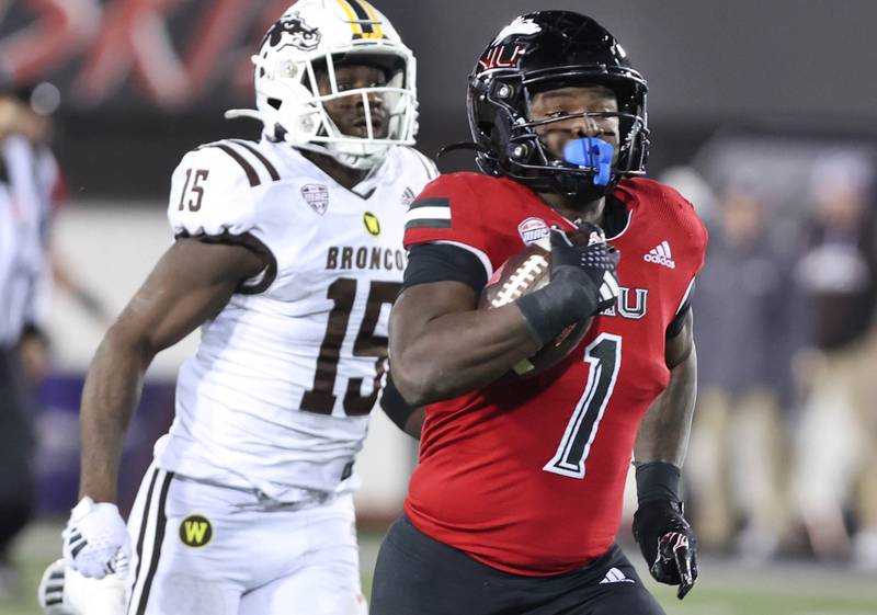 Northern Illinois' Antario Brown sprints ahead of Western Michigan's Donald Willis on his way to a 66 yard touchdown run during their game Tuesday, Nov. 14, 2023, in Huskie Stadium at NIU in DeKalb.