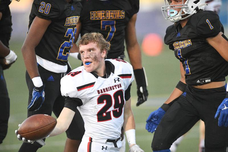 Barrington’s Connor Fitzpatrick gives the ball to the referee after losing his helmet during a run against Warren in a football game in Gurnee on Friday, August 26, 2022.