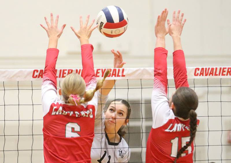 Kaneland's Natalie Remsen spikes the ball between L-P's Maggie Boudreau and Drew Depenbrock on Tuesday, Oct. 7, 2025 in Sellett Gymnasium at L-P High School.