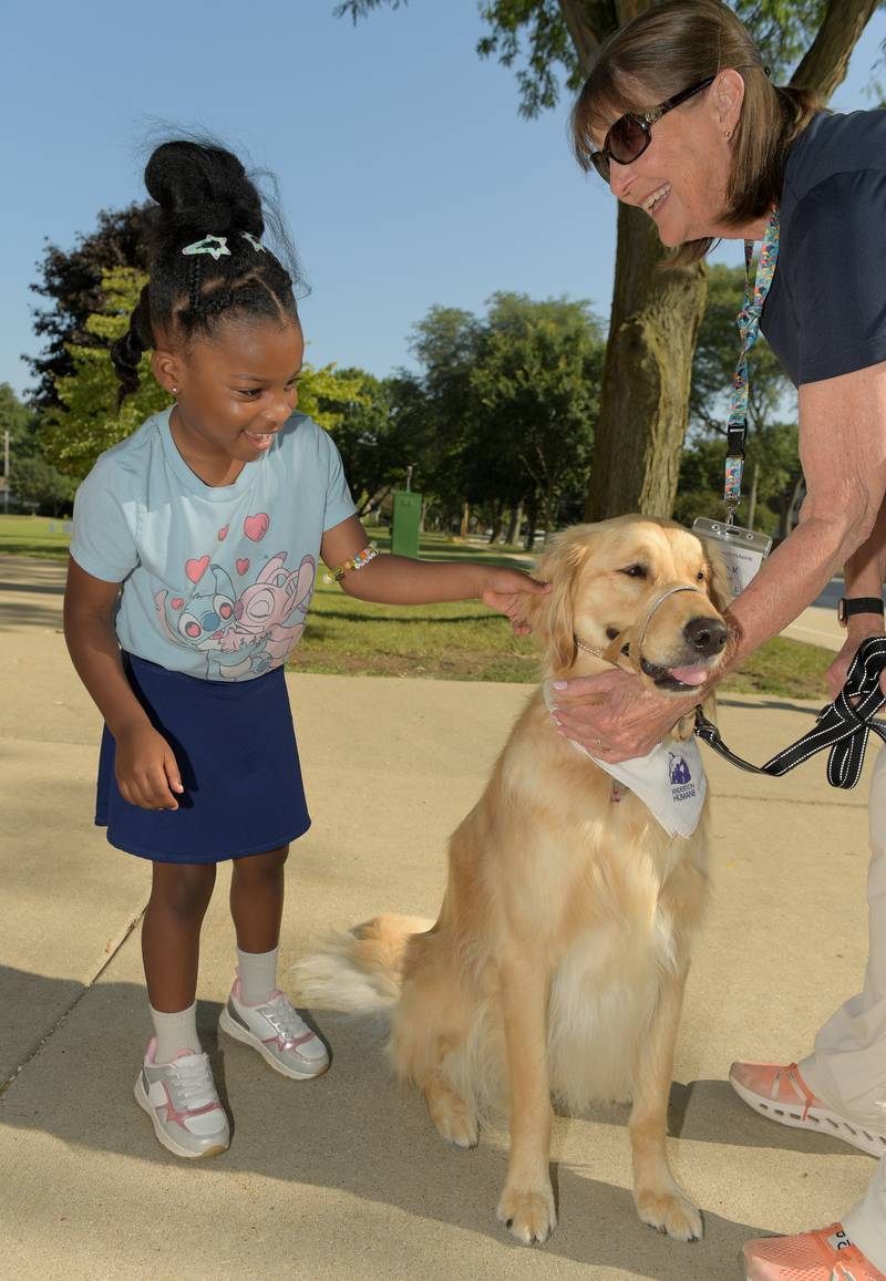 Naomi Codrington, 4 pets theraphy dog “Stanley” after helping drop off her big sister for the first day of classes at Davis Elementary School in St. Charles on Wednesday, Aug 13, 2025.