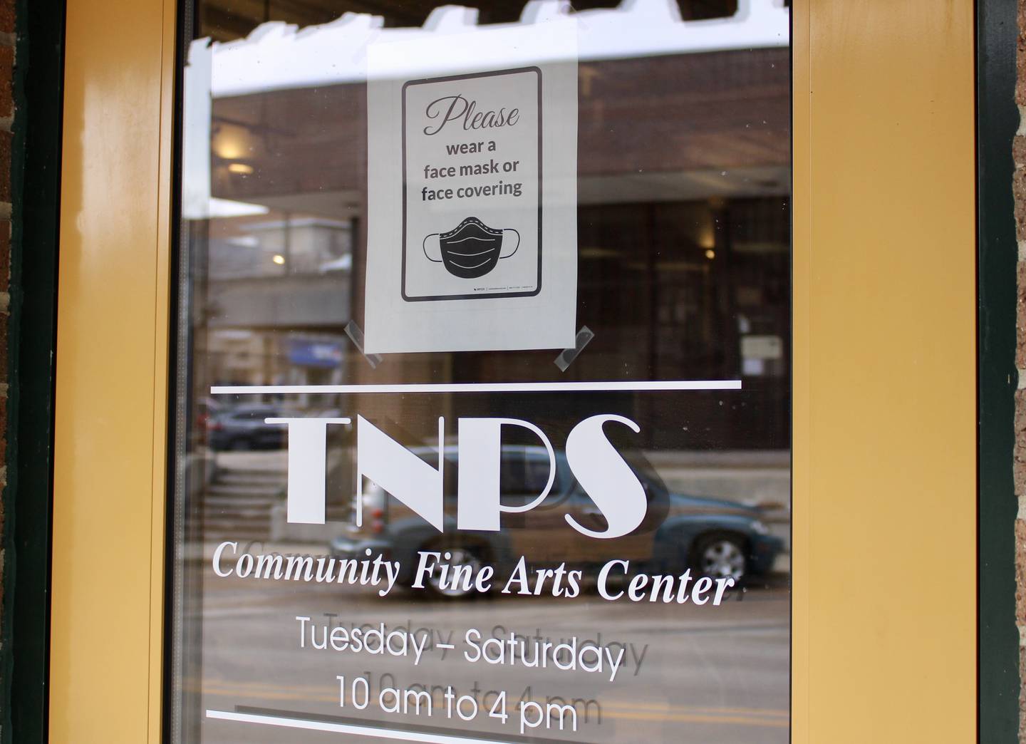 A sign requesting that patrons wear a mask or face covering is attached to the front entrance to The Next Picture Show Community Fine Arts Center on First Street in Dixon.