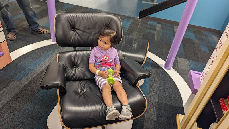 Genesis Treho, 3, of Joliet, explores the concept of time in Ada's "thinking chair" on Wednesday, June 21, 2023, at the Ottawa Street branch of the Joliet Public Library. Ada is one of the characters in “The Questioneers: Read. Question. Think. PLAY!” exhibit based on the Questioneers book series authored by Andrea Beaty and illustrated by David Roberts. The traveling, interactive exhibit is available during library hours through July 29.