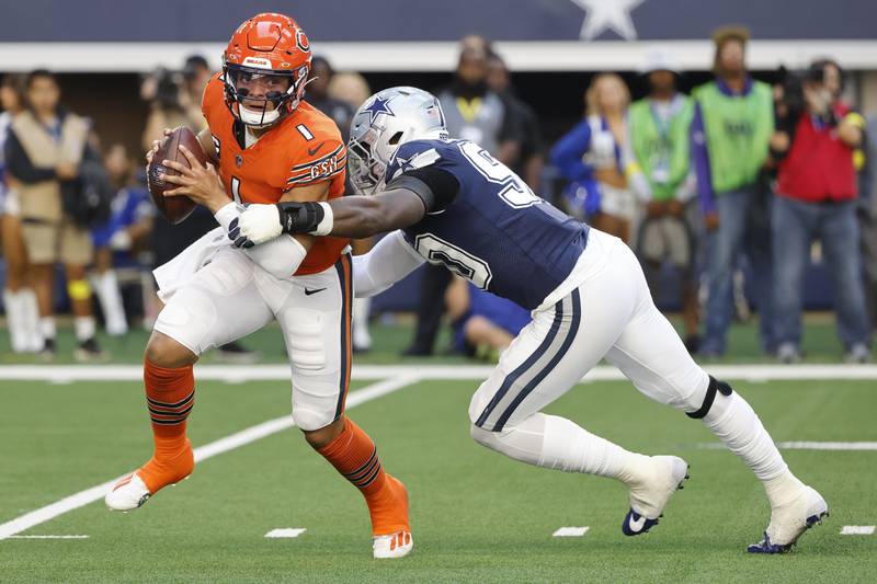 Dallas Cowboys' DeMarcus Lawrence tries to stop Chicago Bears' Justin Fields during the first half, Sunday, Oct. 30, 2022, in Arlington, Texas. (AP Photo/Michael Ainsworth)