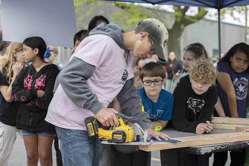 Gavin Staats gives a woodworking demonstration to Lincoln School fourth graders Thursday, May 9, 2024, at Sterling High School FFA's Farmapalooza.