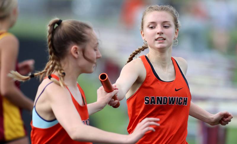 Sandwich’s Erin Lissman, right, hands off to Emily Urbanski in the 3200-meter relay in KRC Conference Track Meet action at Marengo High School in Marengo on Tuesday, May 6, 2025.