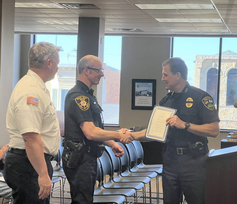 Sycamore Fire Chief Bart Gilmore looks on as Communications Lt. Joseph Rood of the DeKalb County Sheriff’s Office accepts a certificate from Sycamore Police Chief Jim Winters at a the Sycamore City Council meeting on April 15, 2024, when the City Council approved a proclamation declaring April 14-20, 2024, to be National Public Safety Telecommunicators Week in the Sycamore.