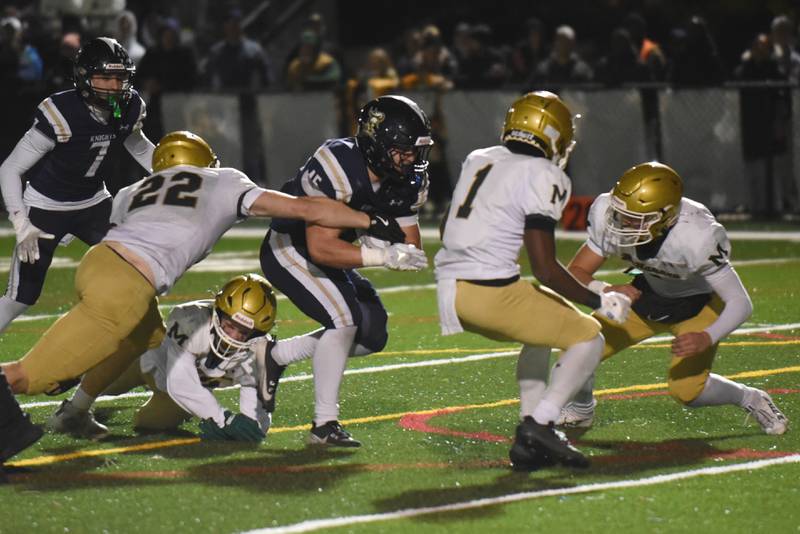 IC Catholic's Foley Calcagno, center, runs through the Bishop McNamara defense during an IHSA Class 3A second round playoff game at IC Catholic Friday, Nov. 7, 2025.