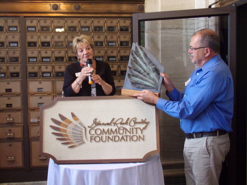 Former Ottawa mayor and one of Starved Rock Country Community Foundation's earliest supporters Bob Eschbach holds up a plaque Thursday, June 1, 2023, made for Pamela Beckett for her service to the foundation that she said she has cherished over the years.