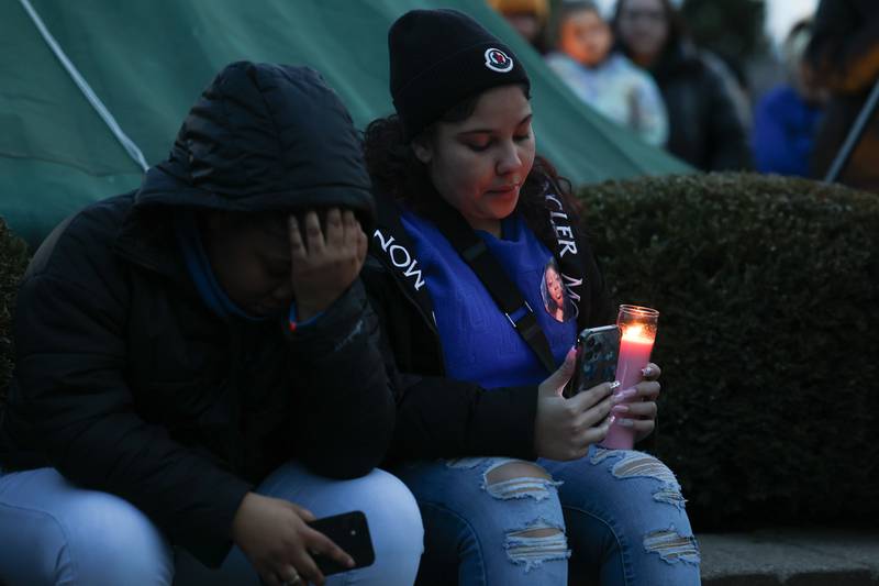 Two young women sit in silence during a candlelight vigil for the victims of the March 5th shooting on Wednesday, March 8th, 2023 in Bolingbrook.