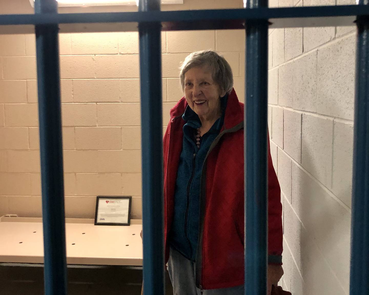 The OSCC chose to leave a holding cell from the old police station intact in the basement of their new home, as a photo opportunity for visitors.  Connie Hilchen, OSCC participant, pictured here.