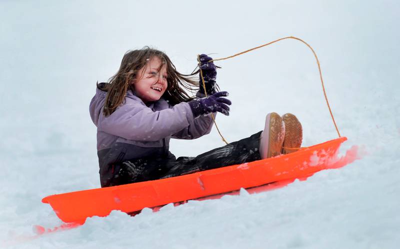 Ava Perez, 7, of Oregon, smiles as she rides her sled down the sledding hill at Oregon Park West on Friday, Jan. 12, 2024.