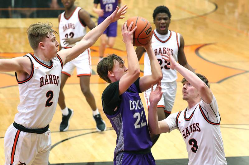 Dixon’s Bryce Feit tries to score between DeKalb’s Sean Reynolds (left) and Brayson Barnhardt during their game Tuesday, Dec. 12, 2023, at DeKalb High School.