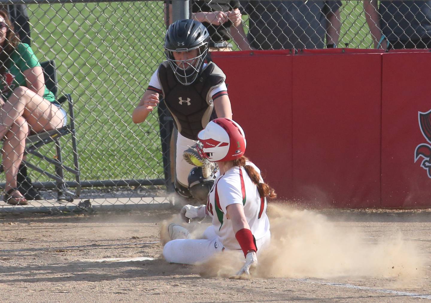 L-P's Addie Duttlinger slides underneath the tag of Ottawa catcher Kendall Lowery to score a run on Friday, April 14, 2023 at Ottawa High School.